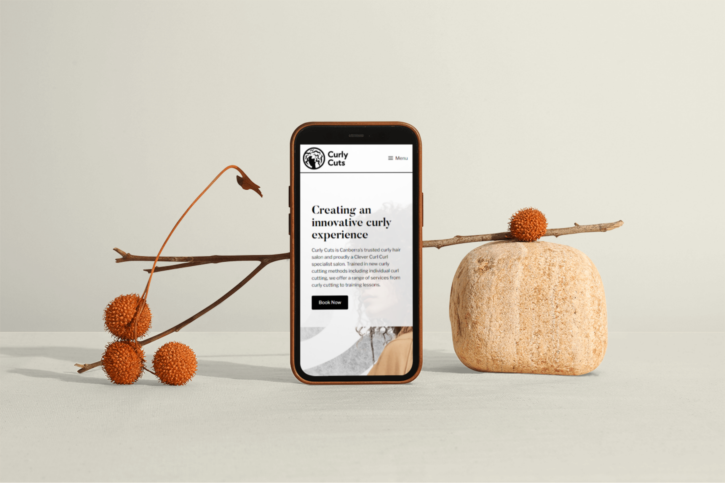 A mockup of Curly Cuts website on an iPhone.